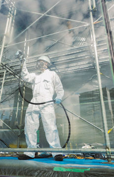 worker on scaffold applying glass coating 