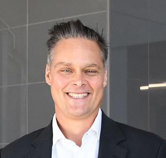 white man with salt and pepper spiked hair, smiling